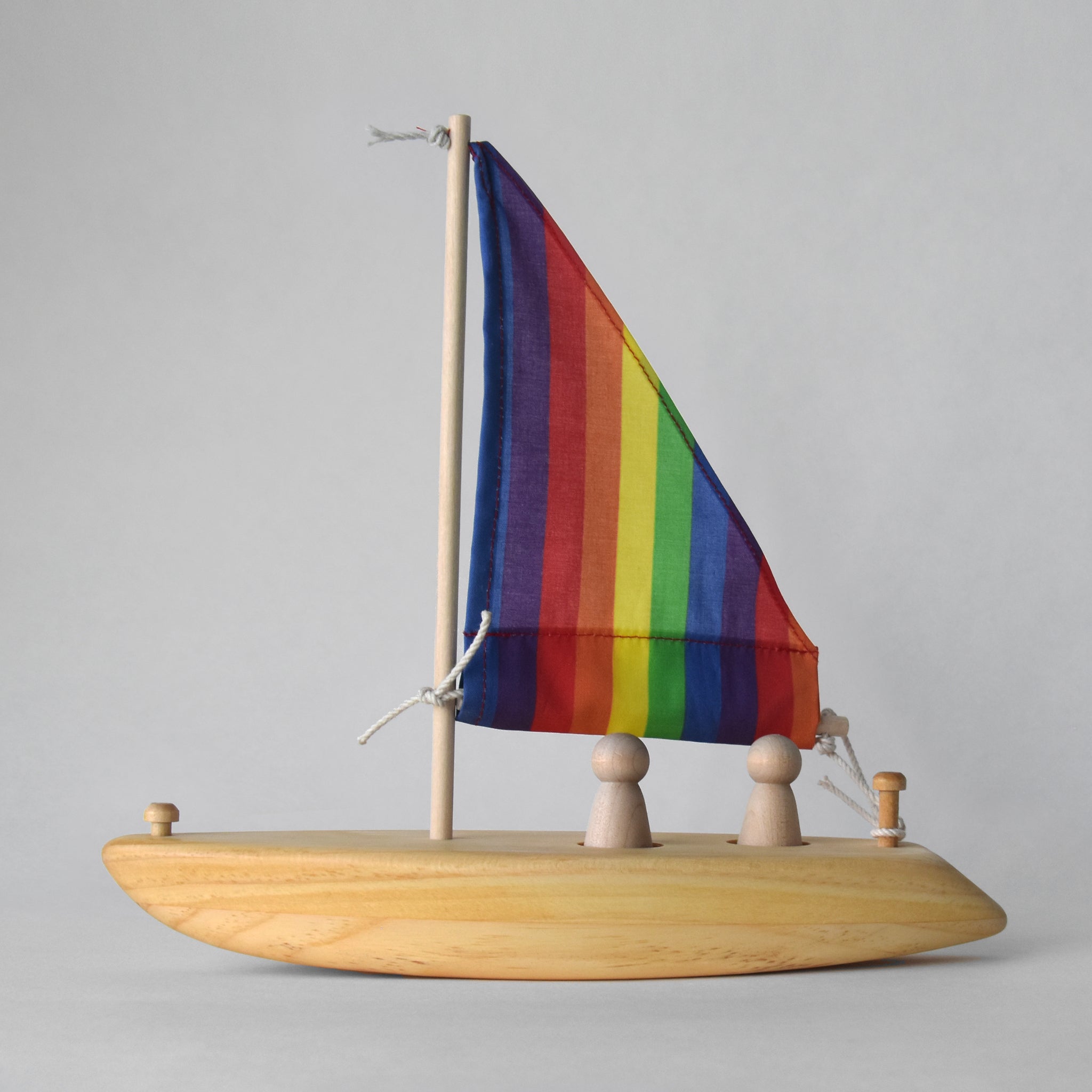 Handmade wooden toy sailboat with rainbow fabric sail | Salt Air Supply